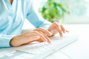 Woman office worker typing on the keyboard