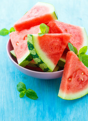 Triangular slices of watermelon with mint on blue wooden backgro
