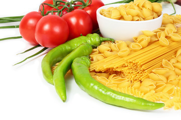 Different types of raw Italian pasta with tomatoes and other vegetables. Top view background. Copy space