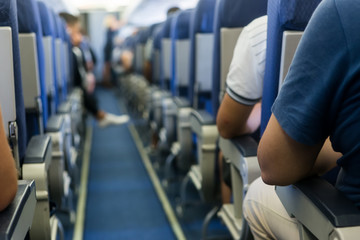 Obraz premium Interior of airplane with passengers on seats waiting to taik of