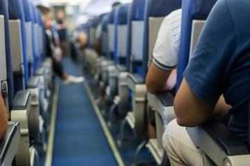 Interior of airplane with passengers on seats waiting to taik of