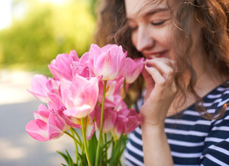 Fototapeta premium Beautiful girl with bunch pink tullips