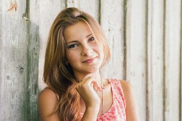 Naklejka premium Fashion young blond woman in pink Tshirt over pale wooden background