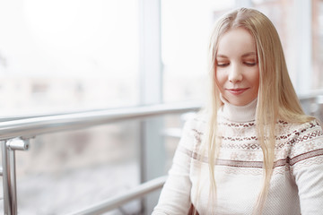 portrait of pretty blonde girl. beautiful girl smiles shyly and hides the eyes. empty space for...