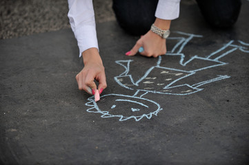 Girl draws with chalk on the pavement
