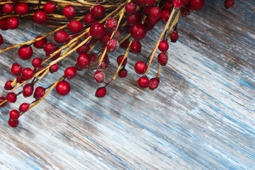 Red Berries on blue wooden background / Christmas background, selective focus