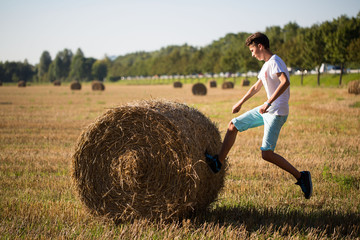 Teenager spring gegen Strohballen