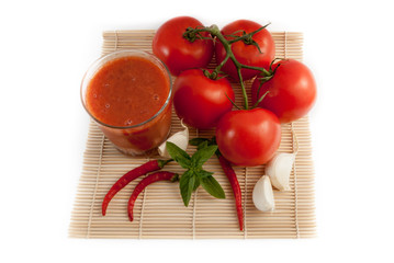 tomatos with glass of juice isolated on white background