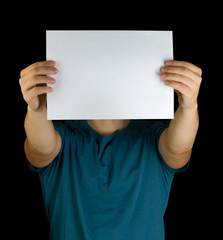 young man holding white blank paper horizontally on extended hands copy space advertisement in front of his face isolated  black