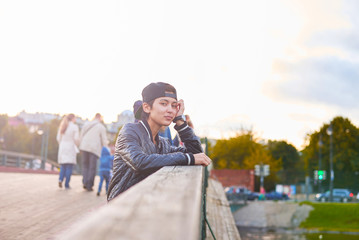 Girl or boy using phone to talk. Portrait of thinking and dreaming asian woman in autumn day. Hipster stay on wooden bridge in the city. Urban concept