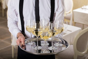 white wine glasses on a tray waiter tray with white wine, a lot of glasses