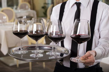 red wine glasses on a tray waiter tray with white wine, a lot of glasses