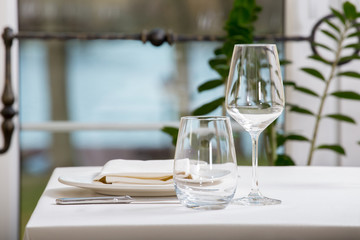 Empty glasses and plates installed in the restaurant, the restaurant served table, white tablecloth and wine