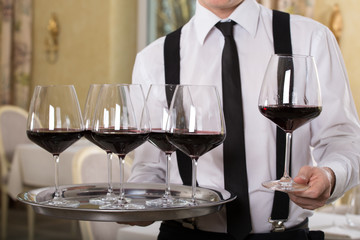 red wine glasses on a tray waiter tray with white wine, a lot of glasses