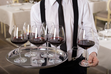 red wine glasses on a tray waiter tray with white wine, a lot of glasses