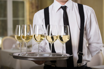 white wine glasses on a tray waiter tray with white wine, a lot of glasses