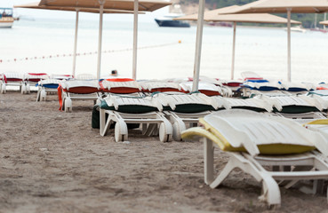 Empty sunbeds on a sandy beach after sunset