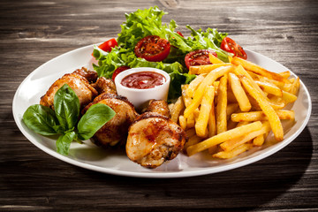 Roast chicken legs with chips and vegetables 