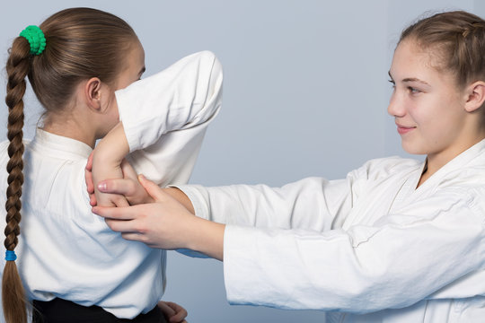 Two girls in black hakama practice Aikido