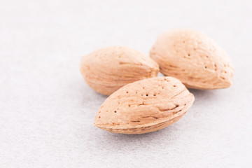 Almonds lying on stone table with copyspace. Food still life with raw nuts.