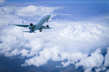 Plane flying above clound with blue sky background.