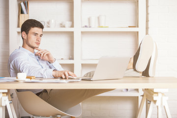 Relaxed young man using laptop