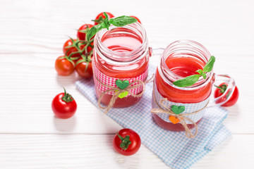 Tomato Juice and Fresh Tomatoes on a White Wooden Background