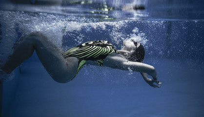 Nadadora profesional entrenando en piscina al aire libre. Giro por debajo del agua.