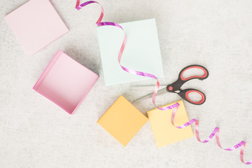 Gift wrapping for a holiday celebration, birthday or surprise party. Preparation of present with ribbon, box and decoration on table. Festive package material.