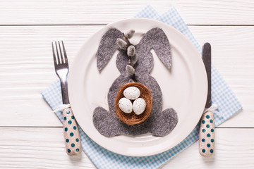 Easter table setting with flowers and eggs on old wooden table