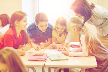 group of school kids writing test in classroom