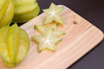 Star apple and averrhoa carambola on wooden block. Fresh star apple fruit on wood table.