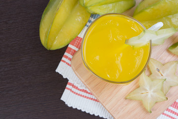 Star apple juice or averrhoa carambola squash on wooden block. Fresh star apple juice on wood table.