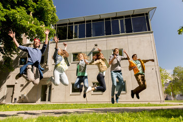 Obraz premium happy teenage students or friends jumping outdoors