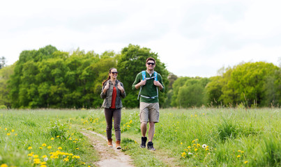 happy couple with backpacks hiking outdoors