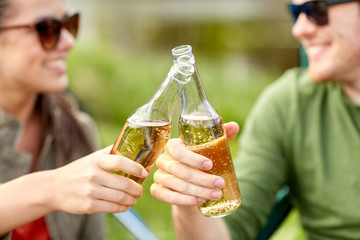 close up of happy couple clinking drinks outdoors