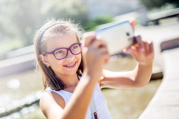 Selfie. Beautiful cute young girl with braces and glasses laughing for a selfie.