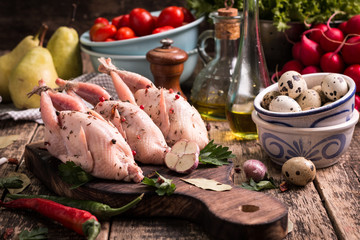 Fresh organic quails on vintage wooden table, healthy food