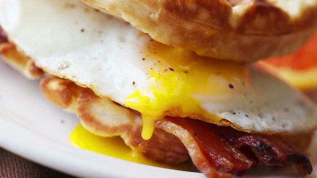 Runny fried egg yolk on breakfast sandwich	