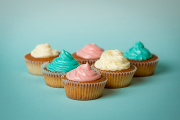 Cupcakes with colorful buttercream over blue background