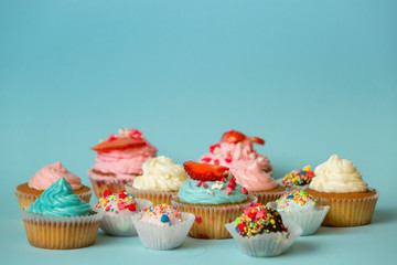 Colorful cupcakes with strawberry and candies with sprinkles on