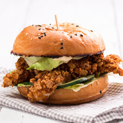 Tasty grilled burger with lettuce and mayonnaise ,on a rustic wooden table