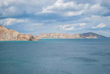 Fototapeta premium calm lagoon and clear water and coast / Sea and mountains against the sky / Sunset on a sea beach with fantastic sky. Sunset light reflection