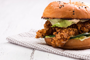 Tasty grilled burger with lettuce and mayonnaise ,on a rustic wooden table