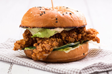 Tasty grilled burger with lettuce and mayonnaise ,on a rustic wooden table
