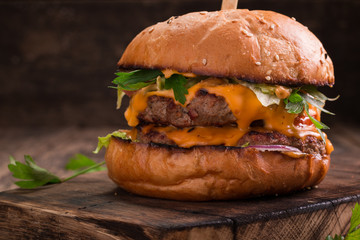 Tasty grilled burger with lettuce and mayonnaise ,on a rustic wooden table