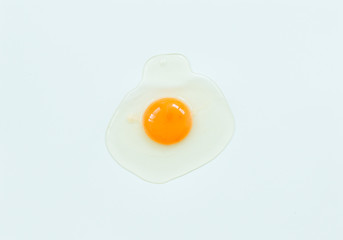 Top view of raw egg on soft blue background.