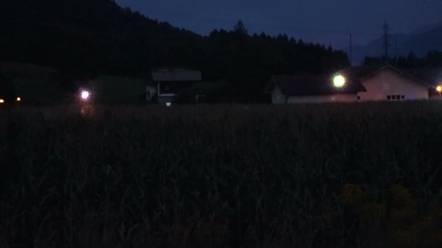 three cgi ufos hovering over a corn crop at night. Handheld shot with low light condition noise