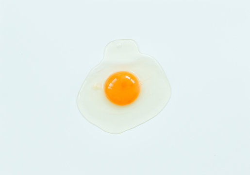 Top view of raw egg on soft blue background.