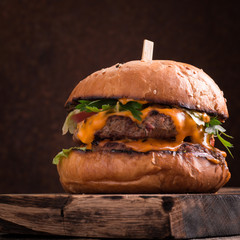 Tasty grilled burger with lettuce and mayonnaise ,on a rustic wooden table